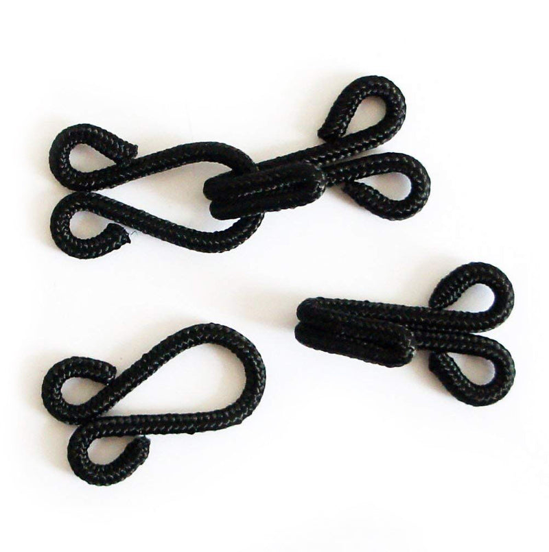 Close-up of large black fur cotton braided hooks and eyes fasteners.
