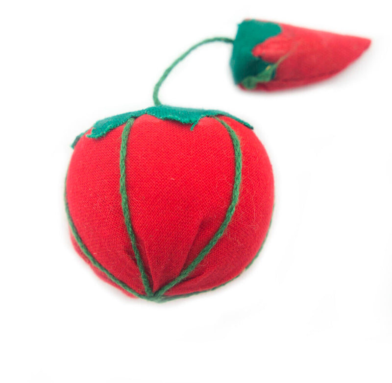 Small tomato pin cushion with a strawberry emery for needle care.
