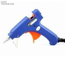 Two hot melt mini glue guns with glue sticks on a table.