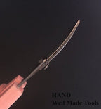 Scissors cutting loose thread on an intricate embroidery design.