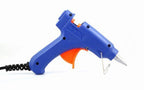 A person using a mini glue gun for crafting.