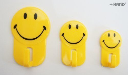 Close-up of a smiley face self adhesive hook showing its strong adhesive backing.