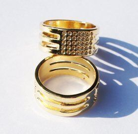 Close-up of a gold ring thimble showing its smooth surface.