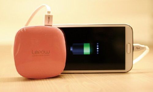 Power bank charging a mobile phone on a table