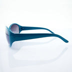 Model wearing stylish turquoise sunglasses outdoors.