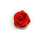 Close-up of small red ribbon rose flower sew on trims.