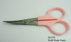 Curved embroidery scissors positioned on a fabric surface.