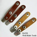 Metal badge clip with leatherette strap attached to an ID badge holder.
