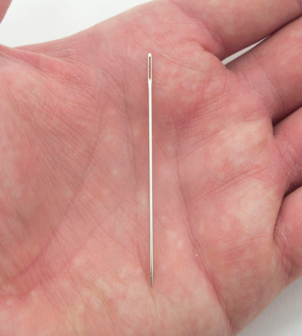 Close-up of a sewing needle showing the sharp pointed end.