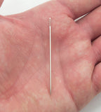 Close-up of a sewing needle showing the sharp pointed end.
