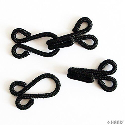 Variety of black fur cotton braided hooks and eyes fasteners on a white background.