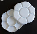 White plastic flower paint tray with 7 wells for mixing colours.