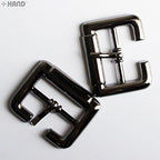 Assorted colours of 23mm metal shoe buckles arranged neatly.