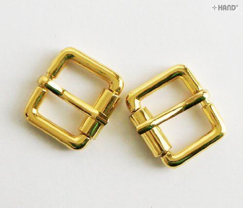 Close-up of a polished gold tone metal belt buckle, showcasing its finish.