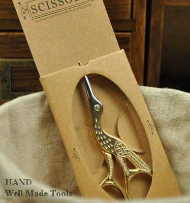 Scissors displayed on a crafting table with embroidery supplies.