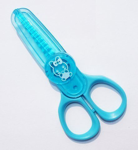 Close-up of kids-safe mini pinking scissors with colourful handles