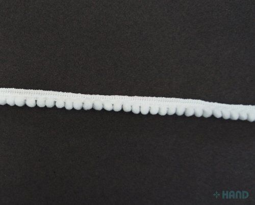 Little white pom pom trim rolled up for easy storage
