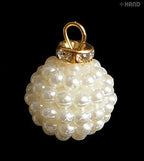 Dangle imitation pearls displayed on a crafting surface.
