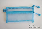 Mesh pencil pouch displayed with travel documents and notes.