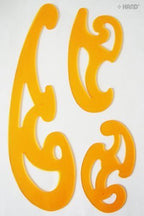 Close-up of orange French curve templates on a craft table.