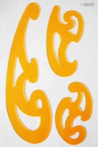 Close-up of orange French curve templates on a craft table.