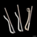 Three metal money clips arranged on a flat surface
