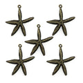 Five bronze colour metal starfish pendants on a white background.