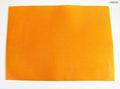 Orange flexible rubber mat on a desk for cutting tasks.