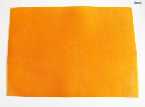 Orange flexible rubber mat on a desk for cutting tasks.