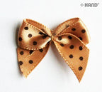 Display of decorative brown ribbon bows with black dots in various arrangements.