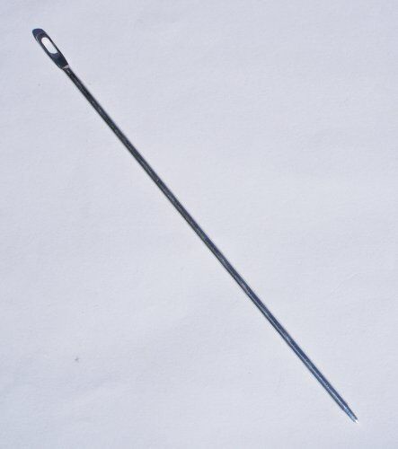 Multi-purpose needle displayed with sewing materials