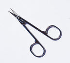 Scissors resting on a fabric surface, showcasing their precision design.