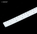 Close-up of the white curve ruler showing measurement markings.
