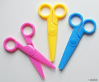 Children's safety scissors displayed on a crafting table.