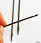 Needle showcasing its length of 8cm for various repairs.