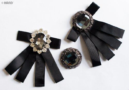 Three assorted vintage brooches displayed on a fabric background.