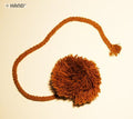 Brown acrylic pom poms displayed on a white background.