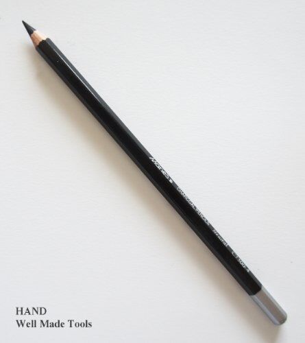 Artist using black charcoal sketching pencils on paper