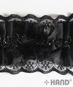 Black nylon lace trim displayed with sewing tools