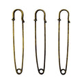 Three large gold kilt pins displayed on a white background.