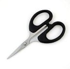 Close-up of scissors cutting through fabric and thread
