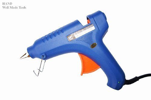Fast hot large glue gun on a workbench with craft supplies