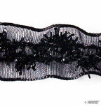 Roll of black elastic satin ribbon on a white background
