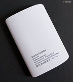 User holding the portable charger while charging a smartphone