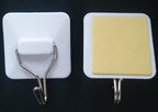 Self-adhesive hook in use in a bathroom setting
