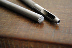 Pack of two eyelet openers with a measuring tape for size reference.