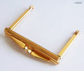 Small gold purse frame with wing kiss clasp lock on a white background.