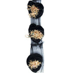 Close-up of black knitted decorative rosettes trim with beading.