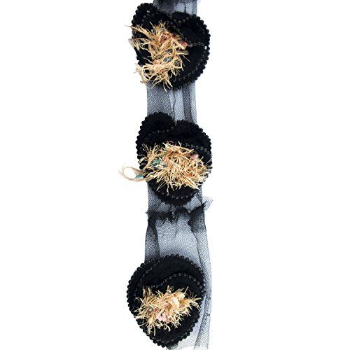 Close-up of black knitted decorative rosettes trim with beading.