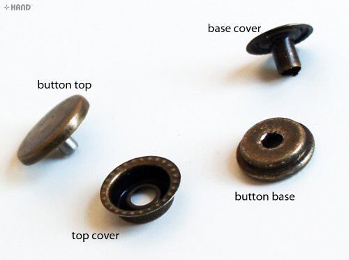 Close-up of 4-part silver press stud buttons on a white background.